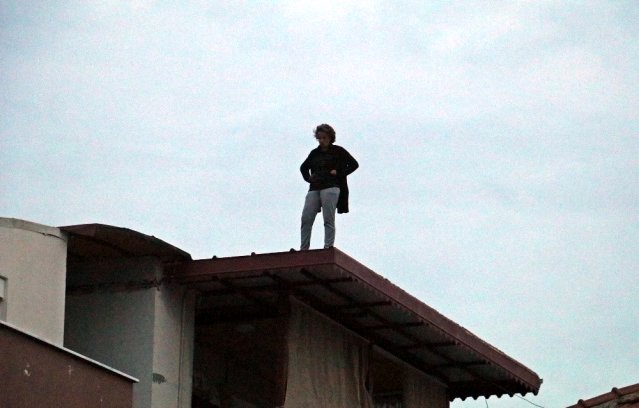 Hakkında arama kararı bulunan kadın, polisi görünce çatıya çıktı