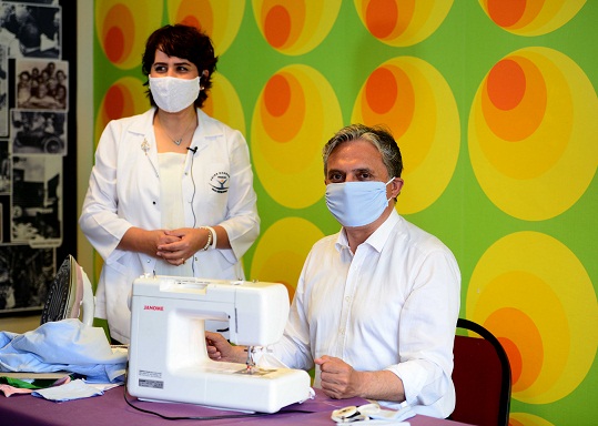 Dikiş makinesinin başına geçti, maske dikti