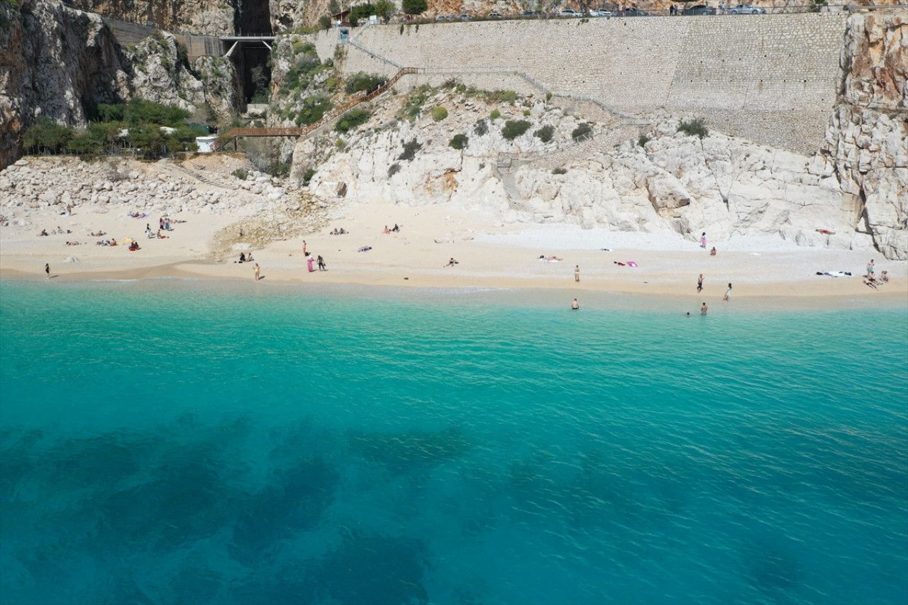 Antalya’nın ünlü Kaputaş Plajı’na gelen turistler güzel havada denize girdi